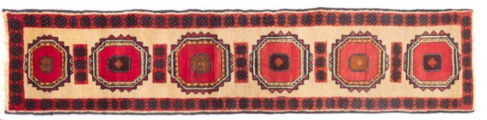 A Turkoman runner, the beige field with six octagonal rose serrated medallions,
