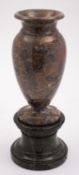 A mottled grey and ochre marble urn, with Italian green serpentine plinth,