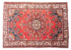 A Baktiar rug, the brick red field with a central light brown shaped lozenge pole medallion,
