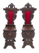 A pair of carved walnut sgabello hall chairs, in Italian style,
