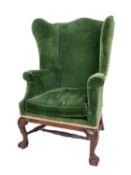 A mahogany and upholstered wing armchair in George II style,