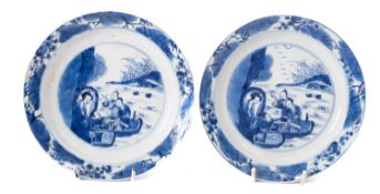 A pair of Chinese porcelain saucer dishes each painted in blue with figures picnicking in a