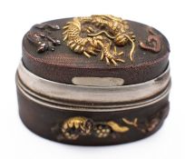A Japanese small oval box and cover, formed from sword furniture, signed under the base, 3.5cm long.