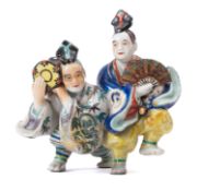 An Arita porcelain figure group of a Kabuki drummer and dancer, 18cm wide,