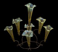 A vaseline glass epergne with seven trumpet shaped glass vases with wavy rims supported on a