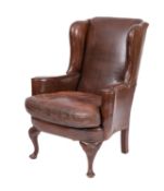 A leather upholstered wingback armchair in Queen Anne style,