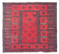 A Turkoman flatweave rug, the field with a central wine ground panel with lozenge medallions,