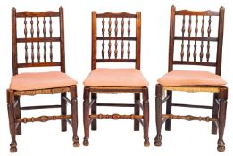 An associated set of nine early 19th Century ash, beech and fruitwood spindle back dining chairs,