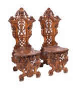 A pair of Italian walnut Sgabello hall chairs in 17th Century style,