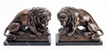 A pair of patinated metal models of lions in antique taste, modern; cast as opposing,