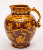 A terracotta jug sgraffito decorated in the North Devon manner with fruiting vine below the caption