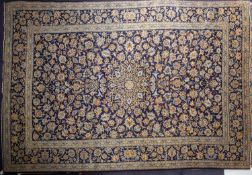 A Kashan carpet, the indigo field with a central geometric open flowerhead pole medallion,