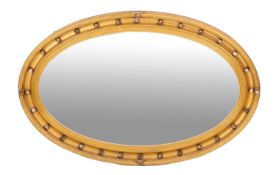 A giltwood framed oval wall mirror in regency taste,