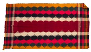 A Kelim rug, the stripped lozenge field in colours of beige, pink, black, green and orange,