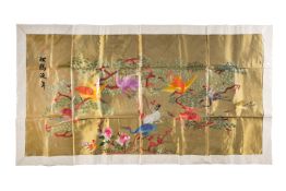A Chinese silk embroidered hanging worked with brightly coloured cranes amongst pine,