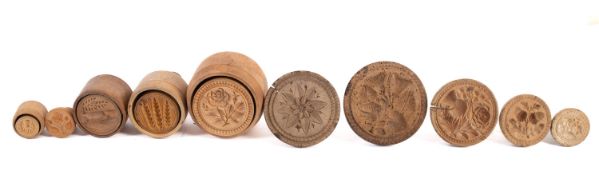A collection of ten turned and carved beech butter moulds,