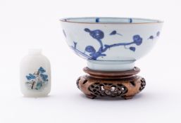 A Nanking Cargo porcelain bowl, painted in blue with a fenced garden containing pierced rocks,