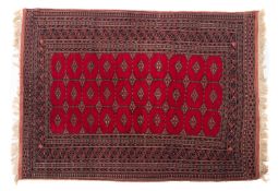 A Turkoman rug, the madder field with an all over hooked lozenge design border, 178cm x 130cm.