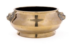 A Chinese polished bronze censer of compressed circular form with lion dog mask handles and flared