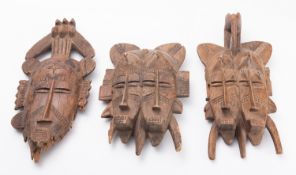 A collection of five carved and decorated wood tribal masks,