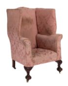 An upholstered wingback armchair in George I style,