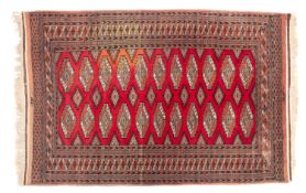 A Turkoman rug, the madder field with two rows of stepped and quartered medallions,