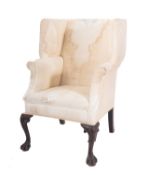 A carved mahogany and upholstered wing armchair in George II style,