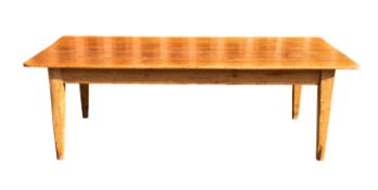A substantial pine kitchen table, early 20th century; the planked top with a drawer at one end,