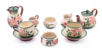 A Devon pottery part tea set, having floral decoration on a green ground, comprising a teapot,