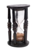 A 19th century oak sand glass with single reservoir between five turned columns, 19cm high.