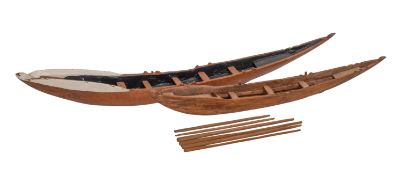 Two hand carved models of rowing boats.