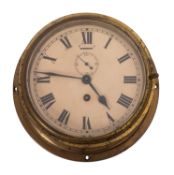 A circular brass bulkhead clock, the enamel dial with Roman numerals and subsidiary seconds dial ,
