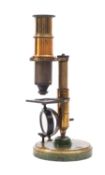 An early 20th century brass student microscope unsigned together with three slides in case