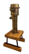A brass ship's pump, maker J Stone & Co, London, mounted on an iron and wood display stand,