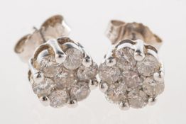 A pair of diamond flowerhead stud earrings, each set with seven brilliant-cut diamonds,
