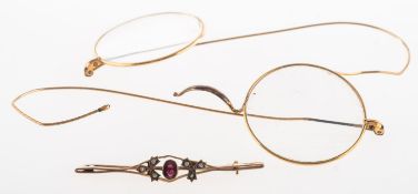 A garnet and seed pearl brooch and a pair of broken spectacles, an openwork brooch,