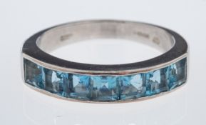 An 18ct white gold aquamarine ring, channel set with seven square-cut aquamarines, approx. 1.