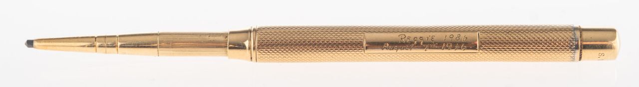 A 9ct gold propelling pencil, with engine turned engraving, UK hallmark, London, makers mark SM&Co,
