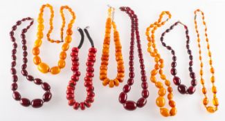 A group of mixed bead necklaces, including a string of graduated red 'amber type' beads,