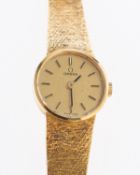 Omega an 18K gold wristwatch the round dial having raised baton numerals,
