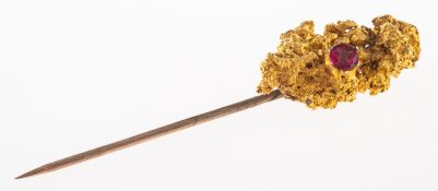 A gold 'nugget' and red paste stone stick pin, gilt pin, length approx. 5.5cm, 9.0grams.
