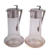A pair of early 20th century German silver and glass claret jugs by Emil Harnisch,
