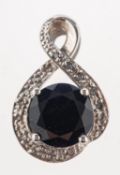 A sapphire and diamond crossover pendant, claw set with a dark blue sapphire,