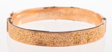 An antique 9ct rose gold bangle, a hinged bangle with foliate carving to the front section,
