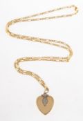 A heart locket with chain, a bi-metal heart locket with foliate detailing to the front and the bale,