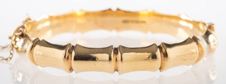 A 1960's 9ct gold bamboo design bangle, hinged, safety chain, UK hallmark, Birmingham 1965,