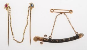 A cloak pin and a scimitar sword brooch, a cloak pin, each pin set to the top with a star,