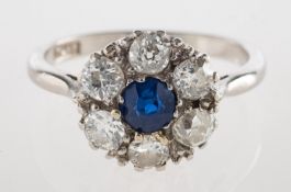 A sapphire and diamond cluster ring, claw set to the centre with a circular-cut sapphire,