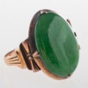 A green hardstone set ring, a ring set with an oval green hardstone cabochon, (possibly jade?),