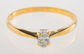 An 18ct gold diamond ring, claw set with an oval-cut diamond, UK import mark for 750,